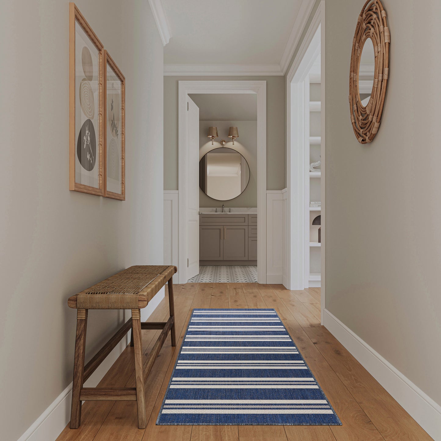 Coastal hallway with pale green walls, wooden bench, blue striped runner, and wicker round mirror near bathroom.