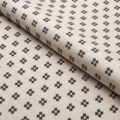 Beige fabric with repeating small dark cross motifs; rolled edge, lightweight geometric textile.