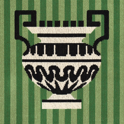 Decorative black-and-white urn with handles on a green striped woven textile.