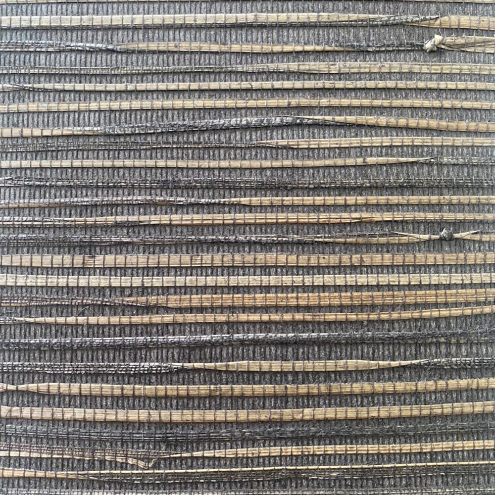 Close-up of grasscloth wallpaper texture with woven natural fibers in brown, black and grey tones.