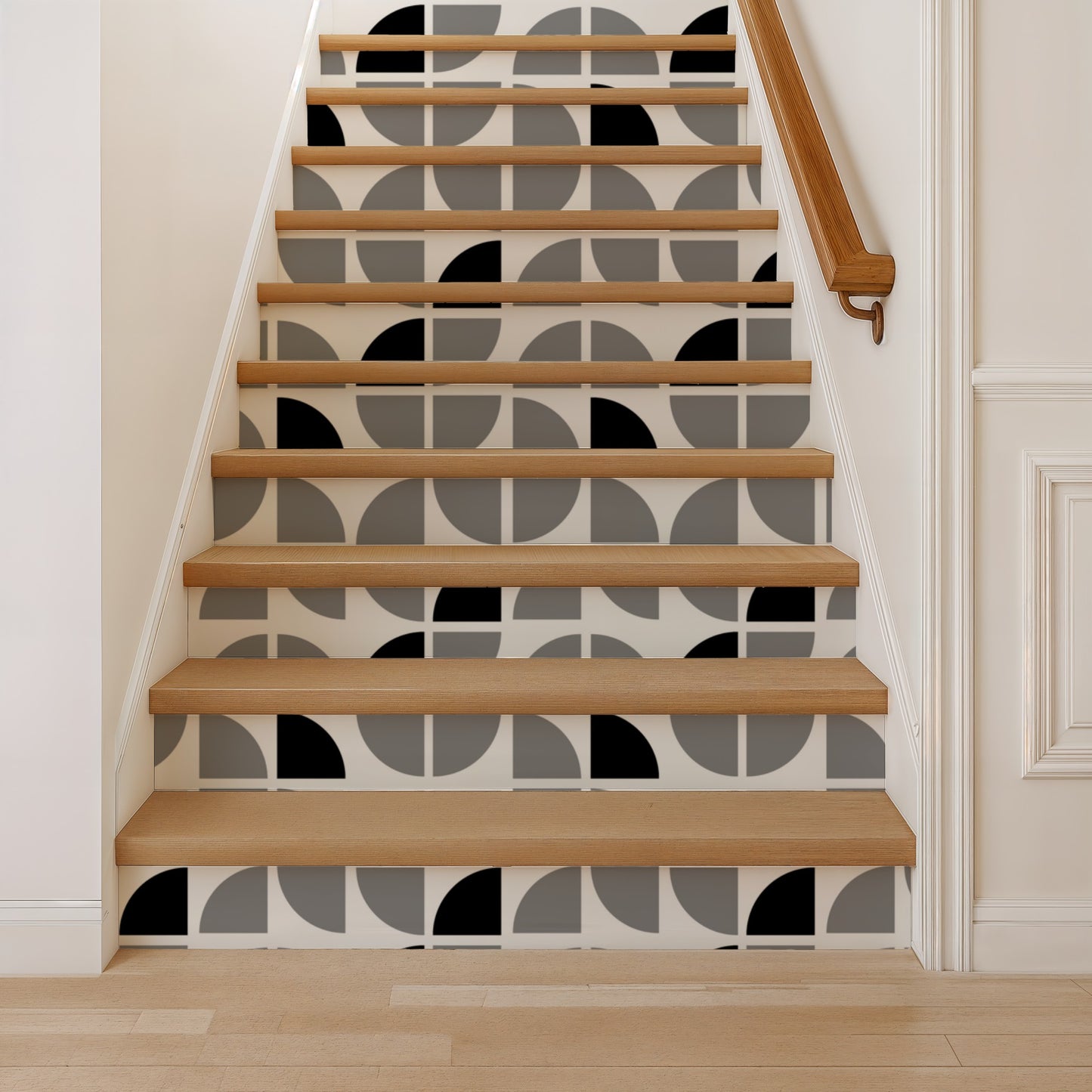 Wall covered in gray geometric crescent wallpaper with an abstract pattern; white walls and a wooden handrail are visible beside a staircase.
