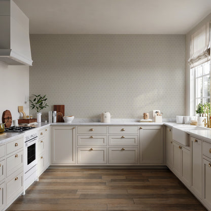 White shaker kitchen with brass hardware, striped hexagonal mosaic gray wallpaper, warm wood floor, gas range left, sink by window on right.