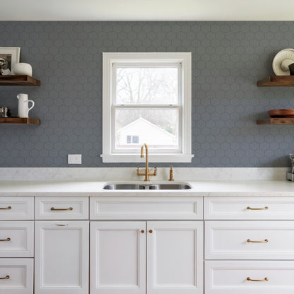 Blue striped hexagonal mosaic peel-and-stick wallpaper on wall; abstract modern blue pattern.