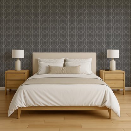 Beige upholstered platform bed with white and beige bedding, light oak nightstands, white lamps, and geometric dark wallpaper.