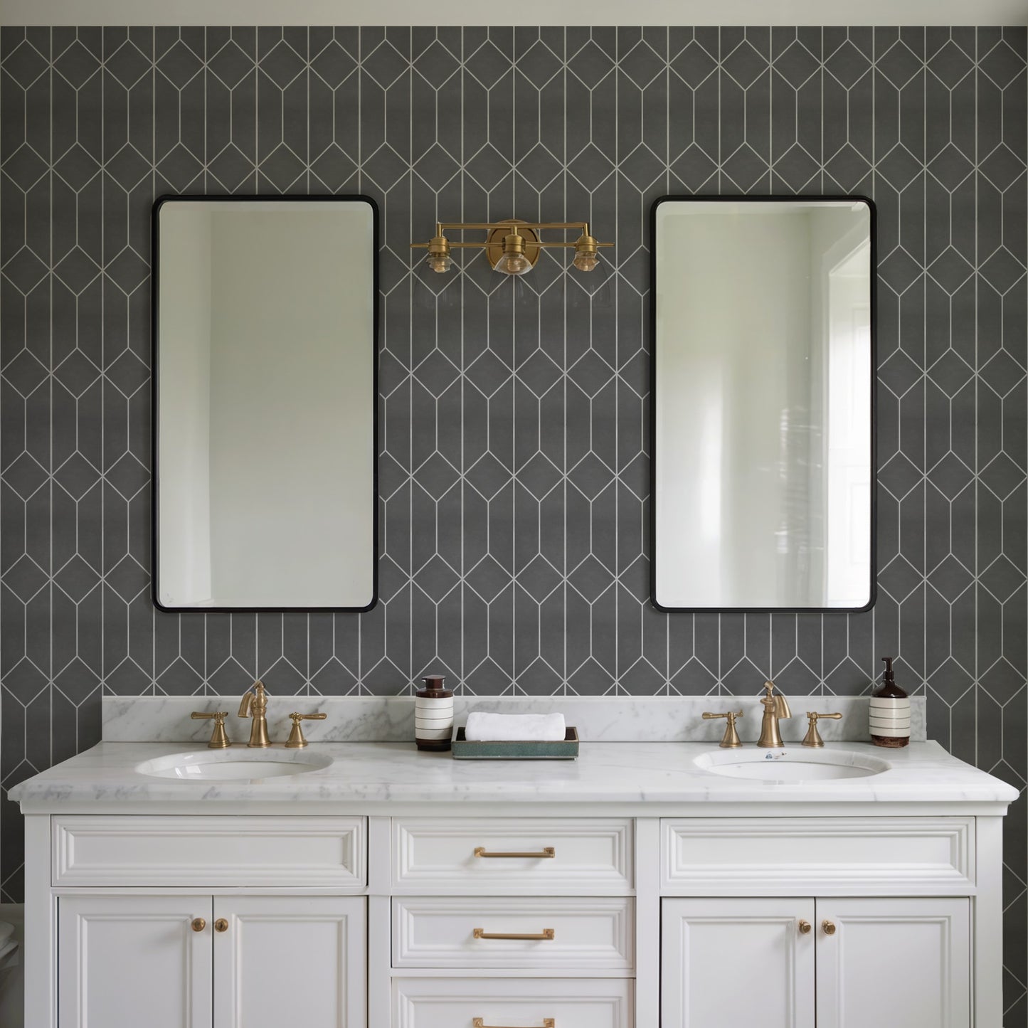 White double vanity with marble countertop, brass fixtures & twin sinks, black-framed mirrors against dark geometric tile.
