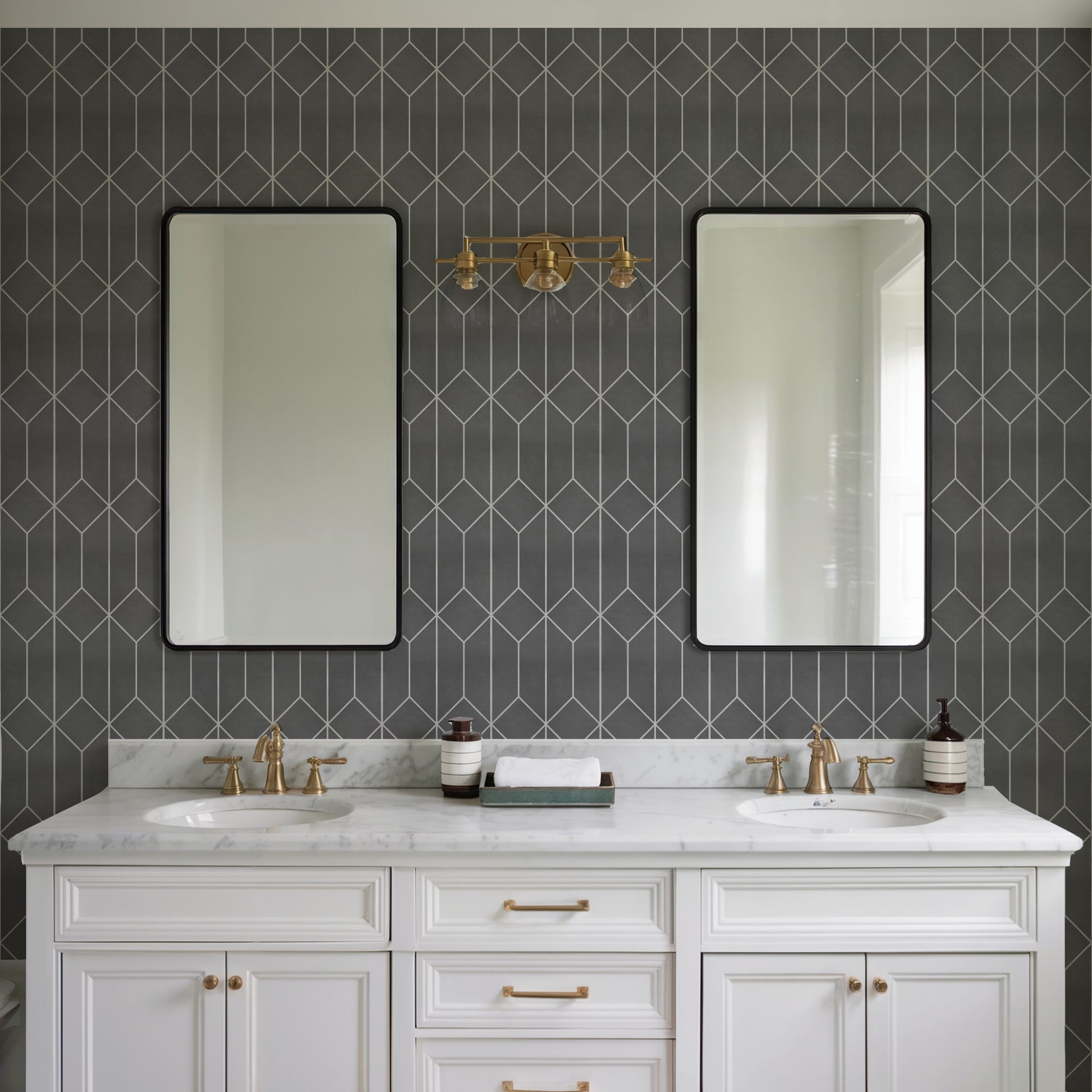 White double vanity with marble countertop, brass fixtures & twin sinks, black-framed mirrors against dark geometric tile.