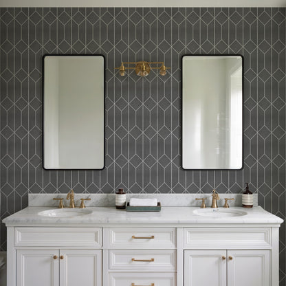 White double vanity with marble countertop, brass fixtures & twin sinks, black-framed mirrors against dark geometric tile.