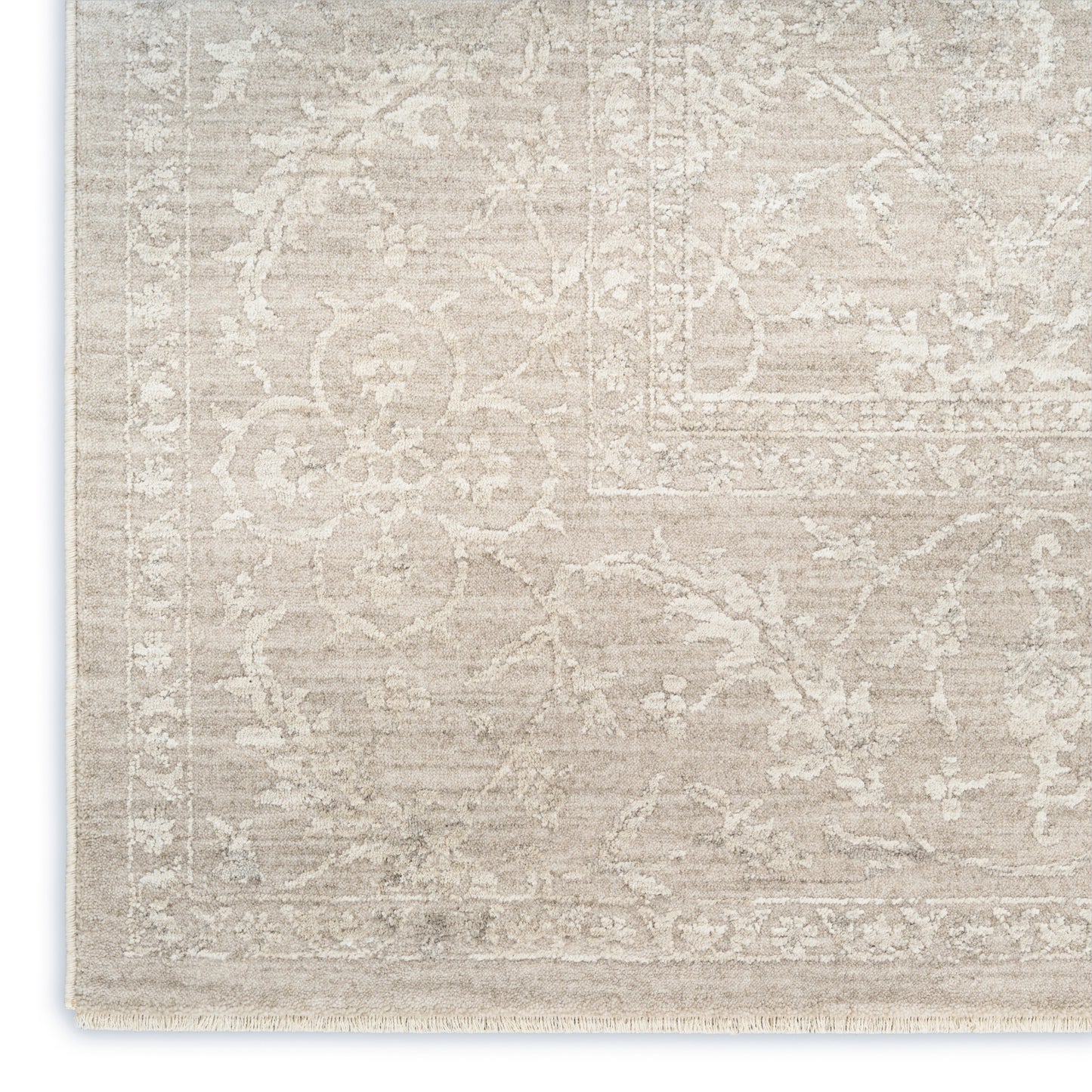 Beige distressed oriental rug with ivory floral pattern and decorative border, fringed edges.