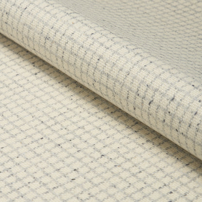 Cream linen-like woven fabric with subtle gray grid pattern, rolled, ideal for upholstery or drapery.