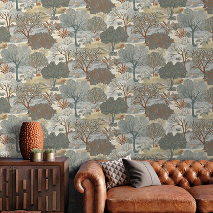 Earth-toned tree wallpaper behind a tufted brown leather sofa; gray cushions and a wood sideboard with an orange vase