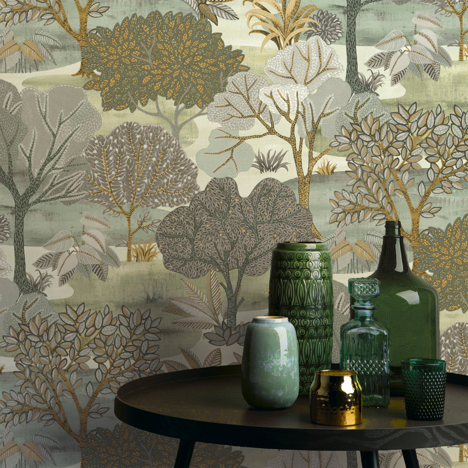 Round black table with green and teal glass vases and an amber jar, set against botanical wallpaper in sage, olive, gold.