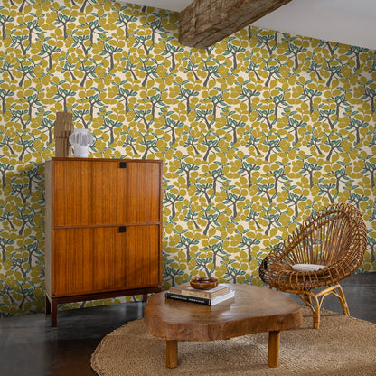 Janneiro Botanica Citron wallpaper featuring layered tropical leaves in yellow and gold tones; non-woven wallcovering suitable for bright accent walls or modern interiors.