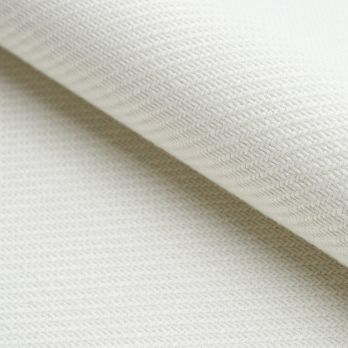 Cream woven fabric close-up with a diagonal fold, showing a soft, textured textile.