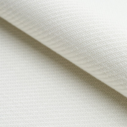 Cream woven fabric close-up with a diagonal fold, showing a soft, textured textile.