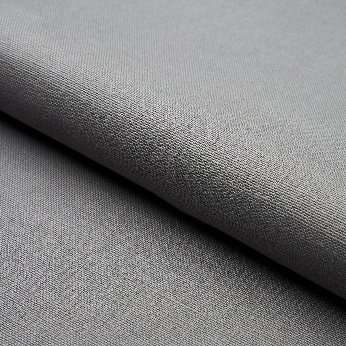 Gray woven fabric with fine texture, folded edge, suitable for upholstery or apparel.