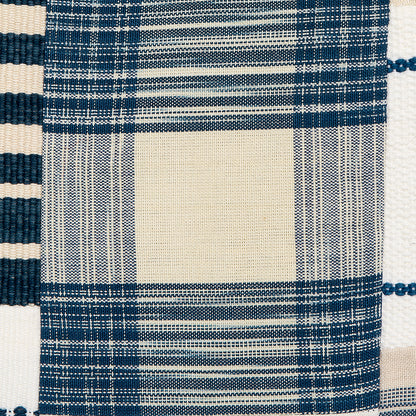 Close-up of woven patchwork fabric in indigo and cream with a large beige center square and striped borders.