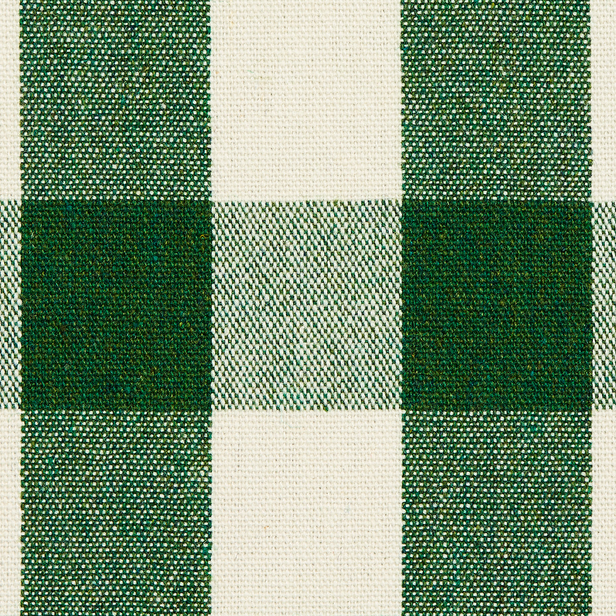 Green and cream plaid woven fabric with dark and olive-green squares; checker pattern for apparel or home decor.