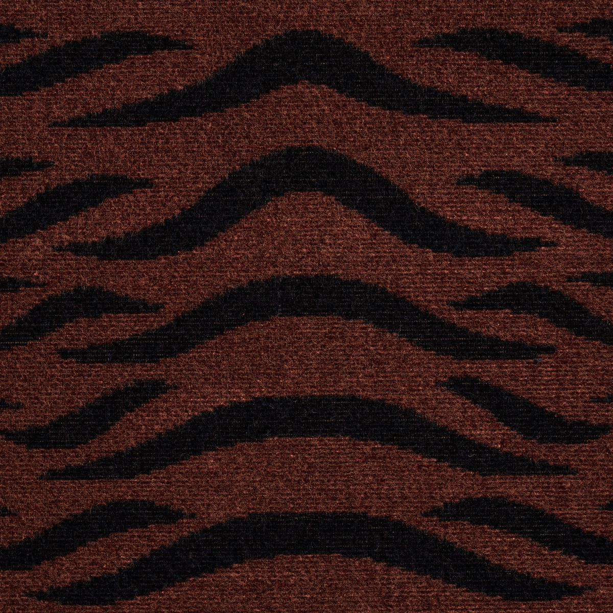 Brownish-red rug with bold black wavy tiger-stripe pattern; plush textured fabric.