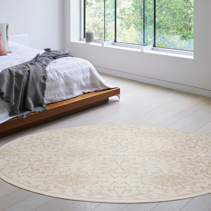 Round beige patterned area rug on light wood floor in bright modern bedroom with low wooden bed and gray throw.