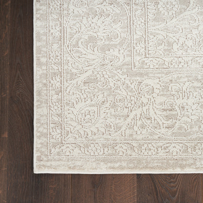 Beige traditional oriental rug with cream floral border on dark wood floor; rectangular decorative area rug.