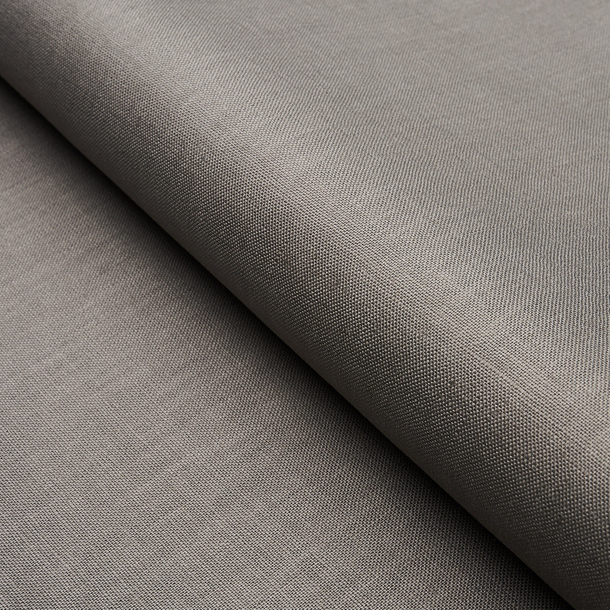 Taupe-gray woven fabric with tight texture, folded drape; versatile upholstery or apparel material.
