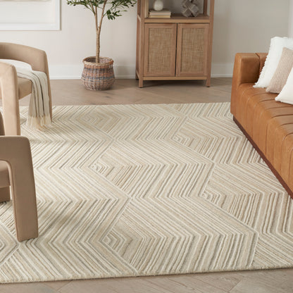 Neutral chevron-pattern rug in cream and beige tones, shown in a modern living room with light seating and a woven cabinet.
