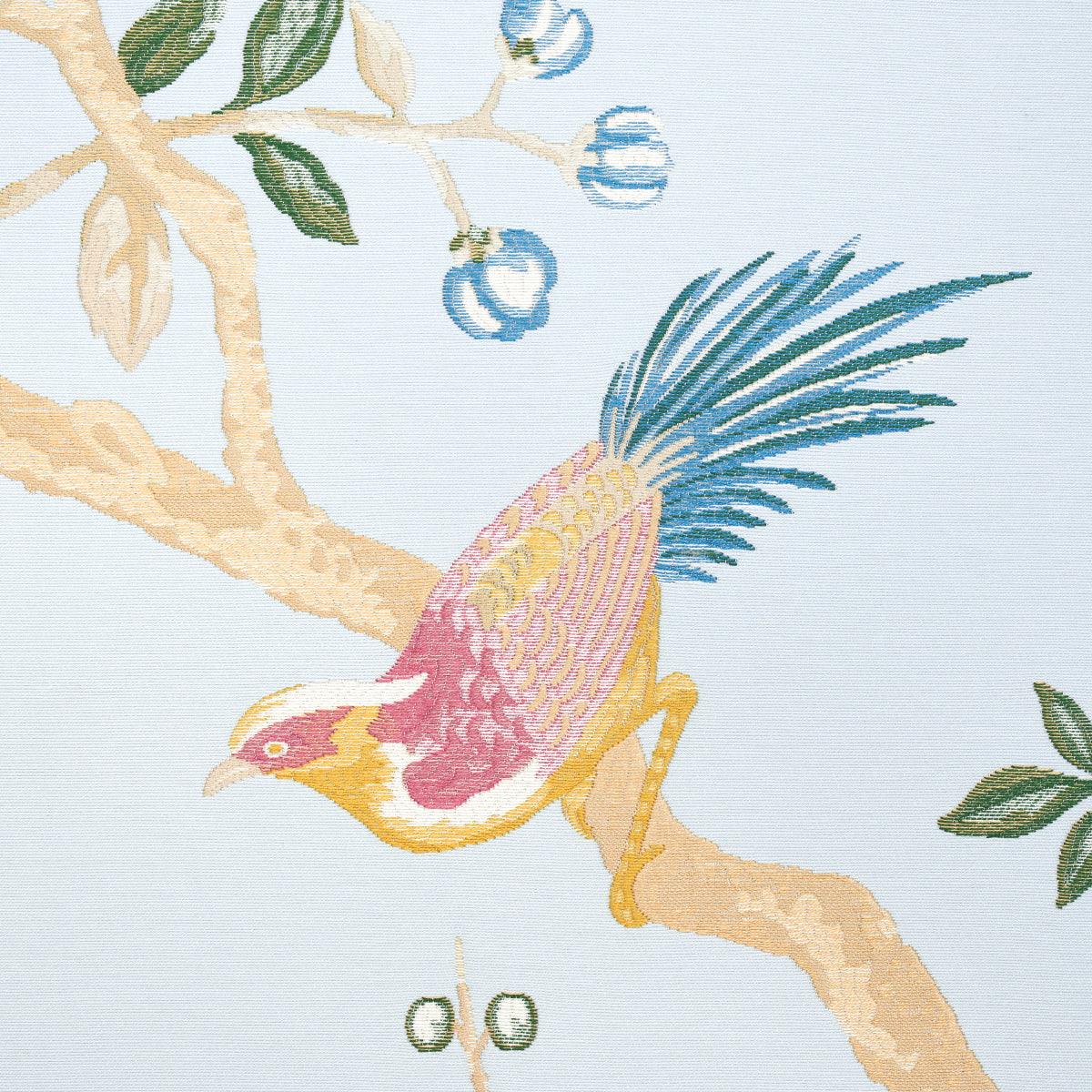 Decorative fabric print of a colorful bird with yellow head, pink chest and blue tail on a beige branch with green leaves.