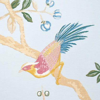 Decorative fabric print of a colorful bird with yellow head, pink chest and blue tail on a beige branch with green leaves.