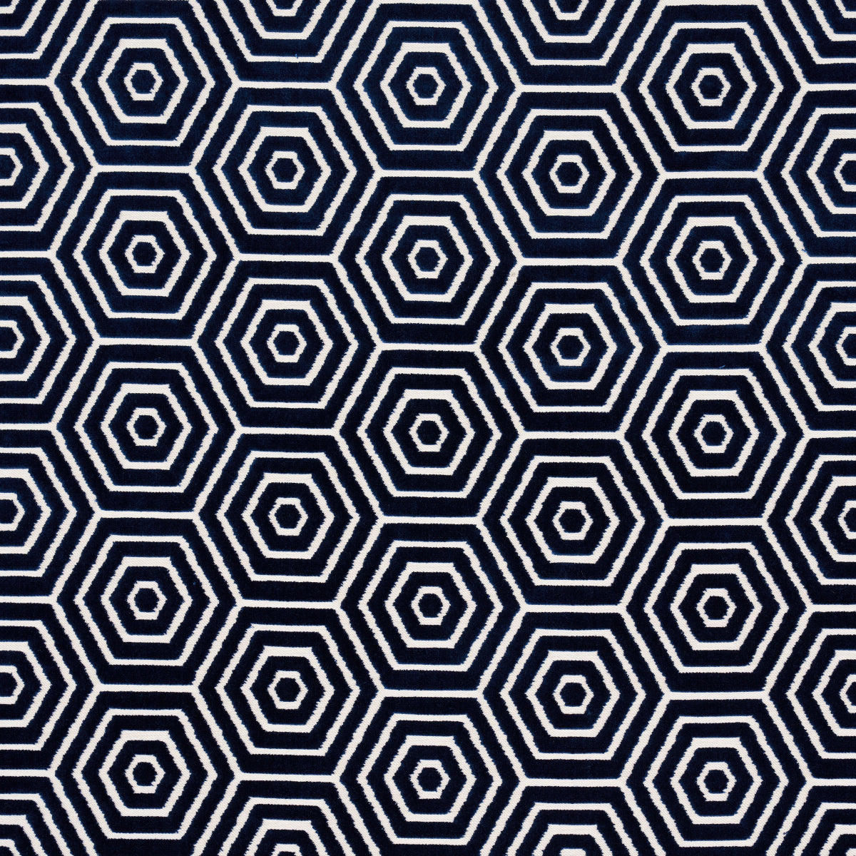 Dark navy fabric with a repeating white nested hexagon pattern; bold geometric print for upholstery or cushions.