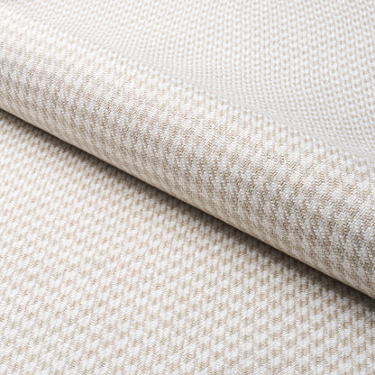 Grey woven fabric with a houndstooth pattern and rolled edge; upholstery or drapery textile.