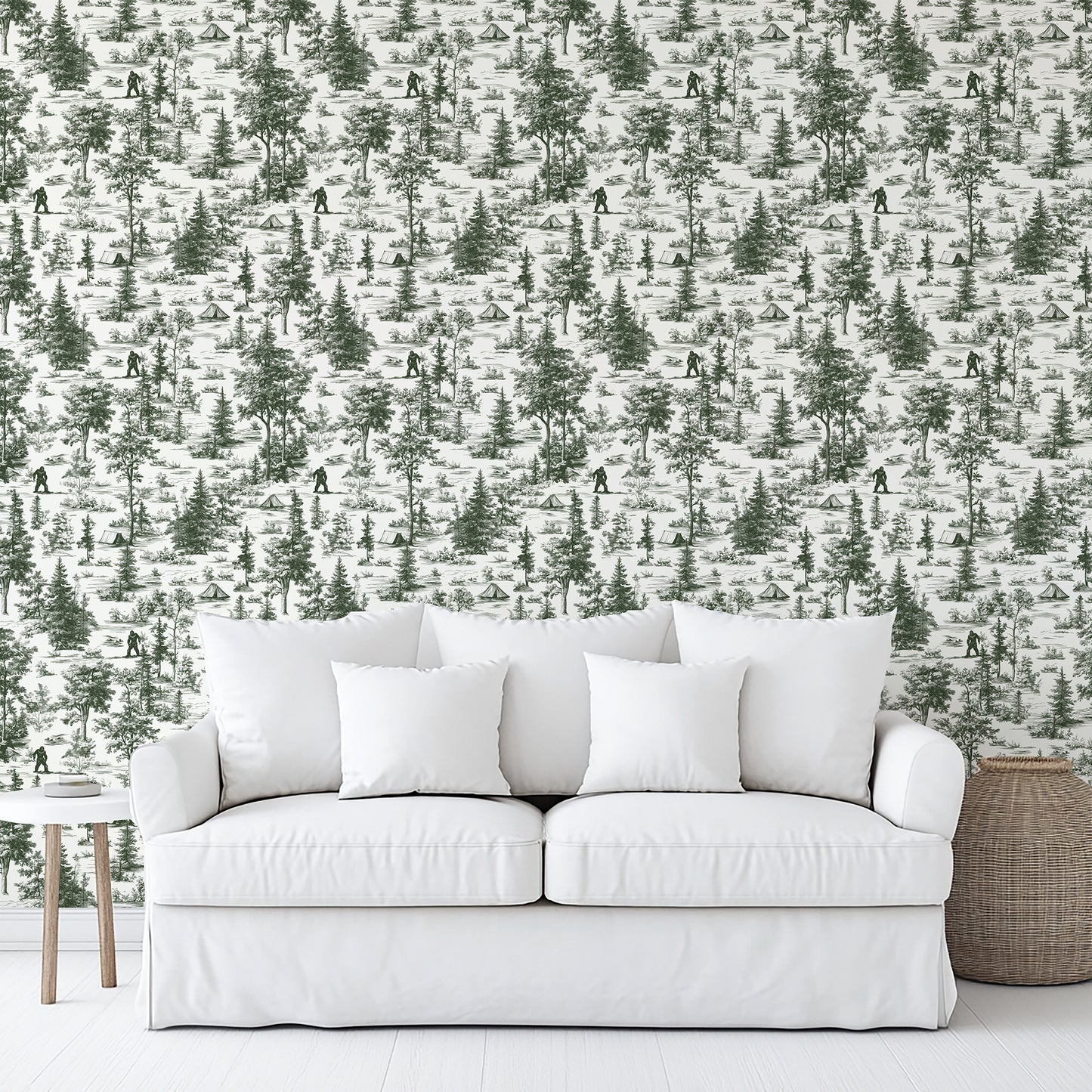 Green Bigfoot novelty toile wallpaper (peel-and-stick) on the wall behind a white upholstered sofa with cushions; wood side table and wicker basket.