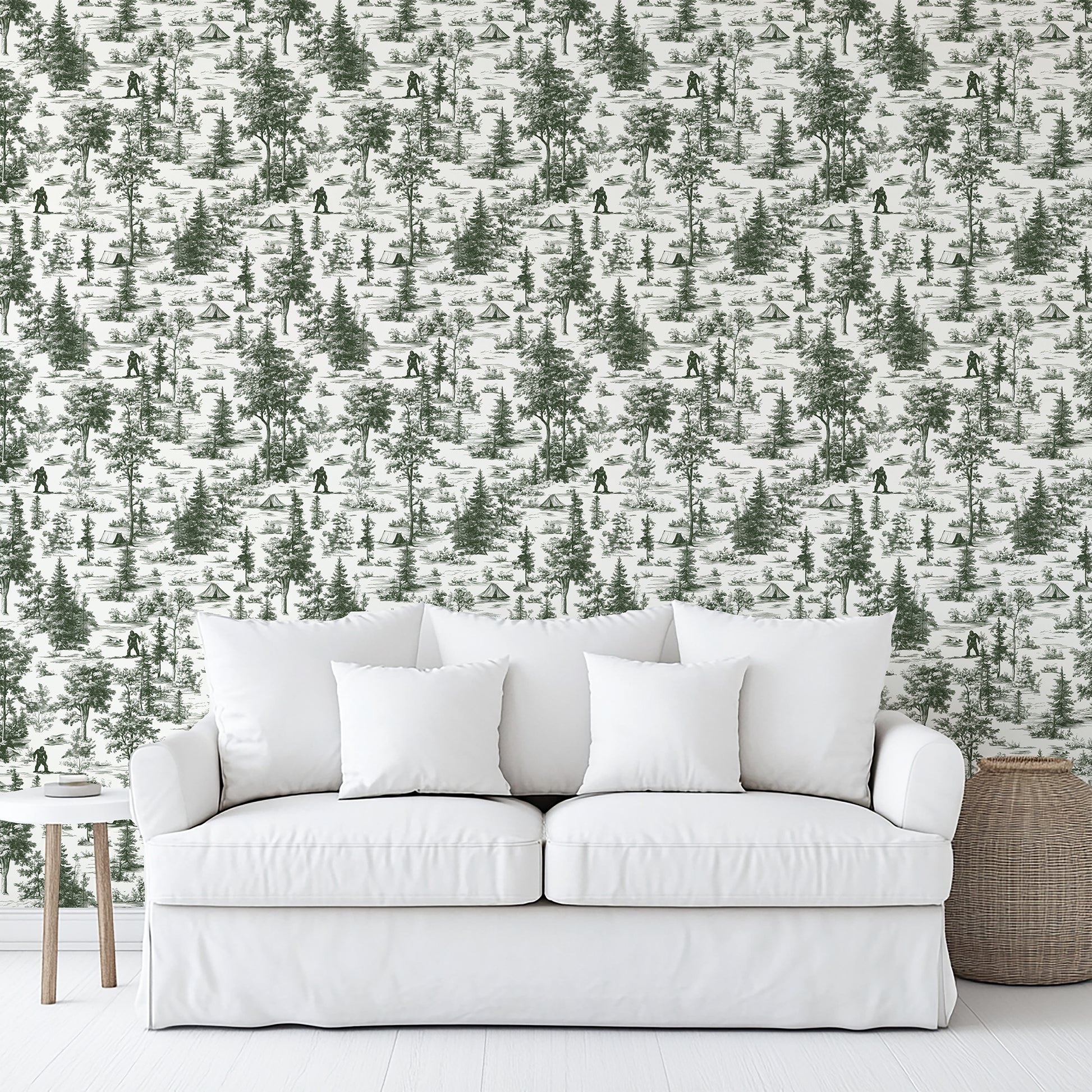 Green Bigfoot novelty toile wallpaper (peel-and-stick) on the wall behind a white upholstered sofa with cushions; wood side table and wicker basket.