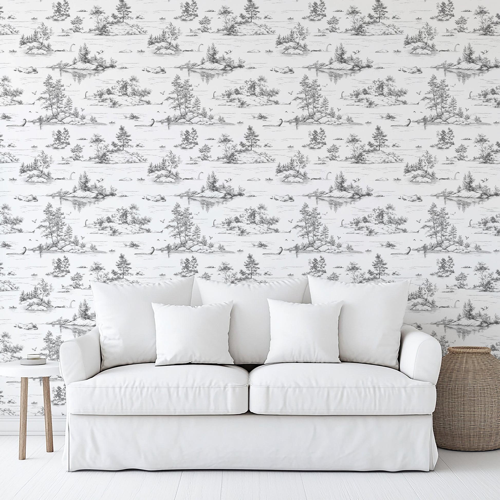 White sofa with three square cushions against toile wallpaper; light-wood side table and woven basket.