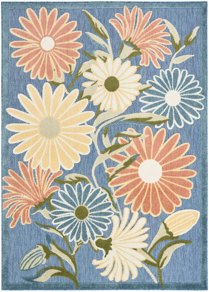 Tufted floral area rug with oversized daisies in peach, yellow, and blue on a denim blue background with green stems.