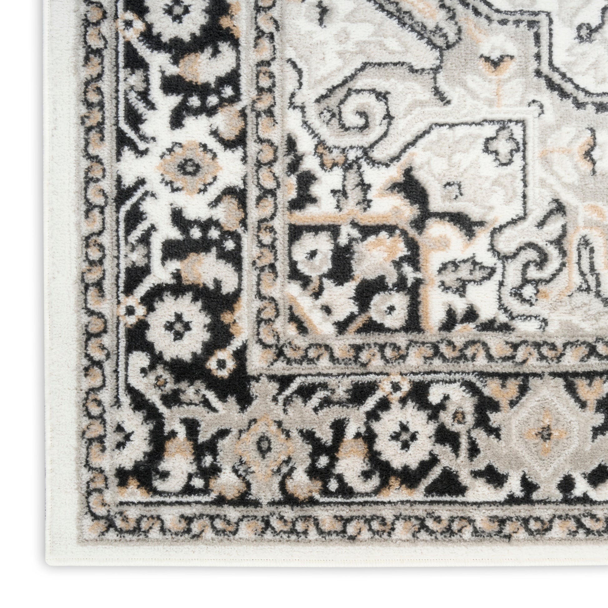 Close-up of a traditional Persian-style area rug showing ivory, black & tan floral pattern with ornate border.