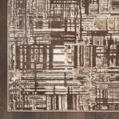 Abstract brown and beige rectangular rug with geometric block patterns on a dark wood floor.