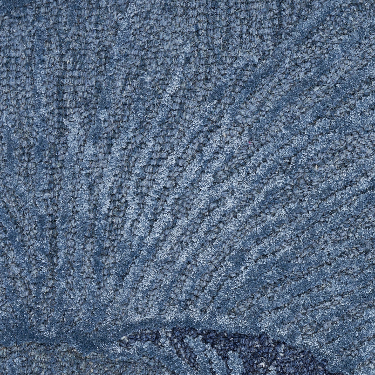 Blue textured terry towel close-up with dense loop fibers and a decorative stitched border.