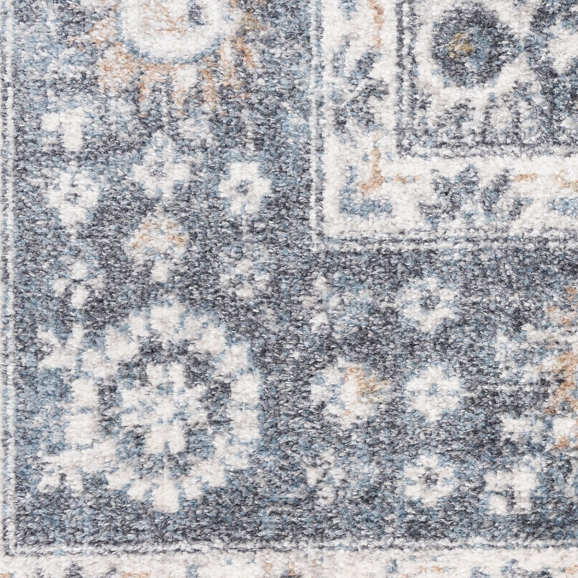 Blue-gray distressed oriental rug with white floral motifs and beige accents; plush rectangular floor covering.