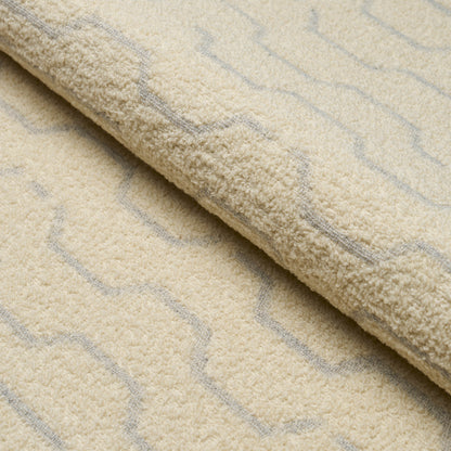 Cream shag rug with light gray zigzag pattern and plush pile, rolled edge showing texture.