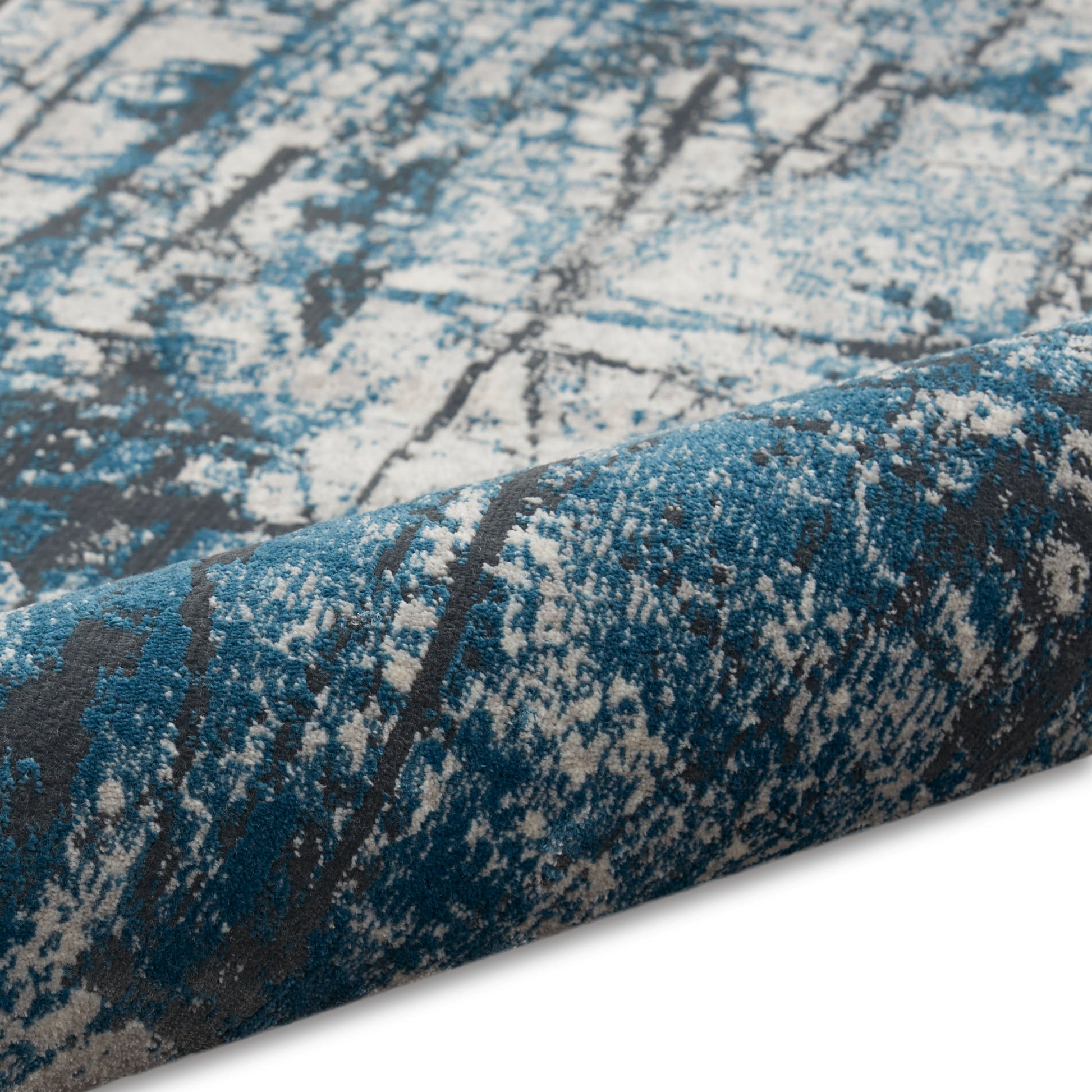 Blue teal abstract patterned rug with distressed gray and cream speckling, rolled edge.