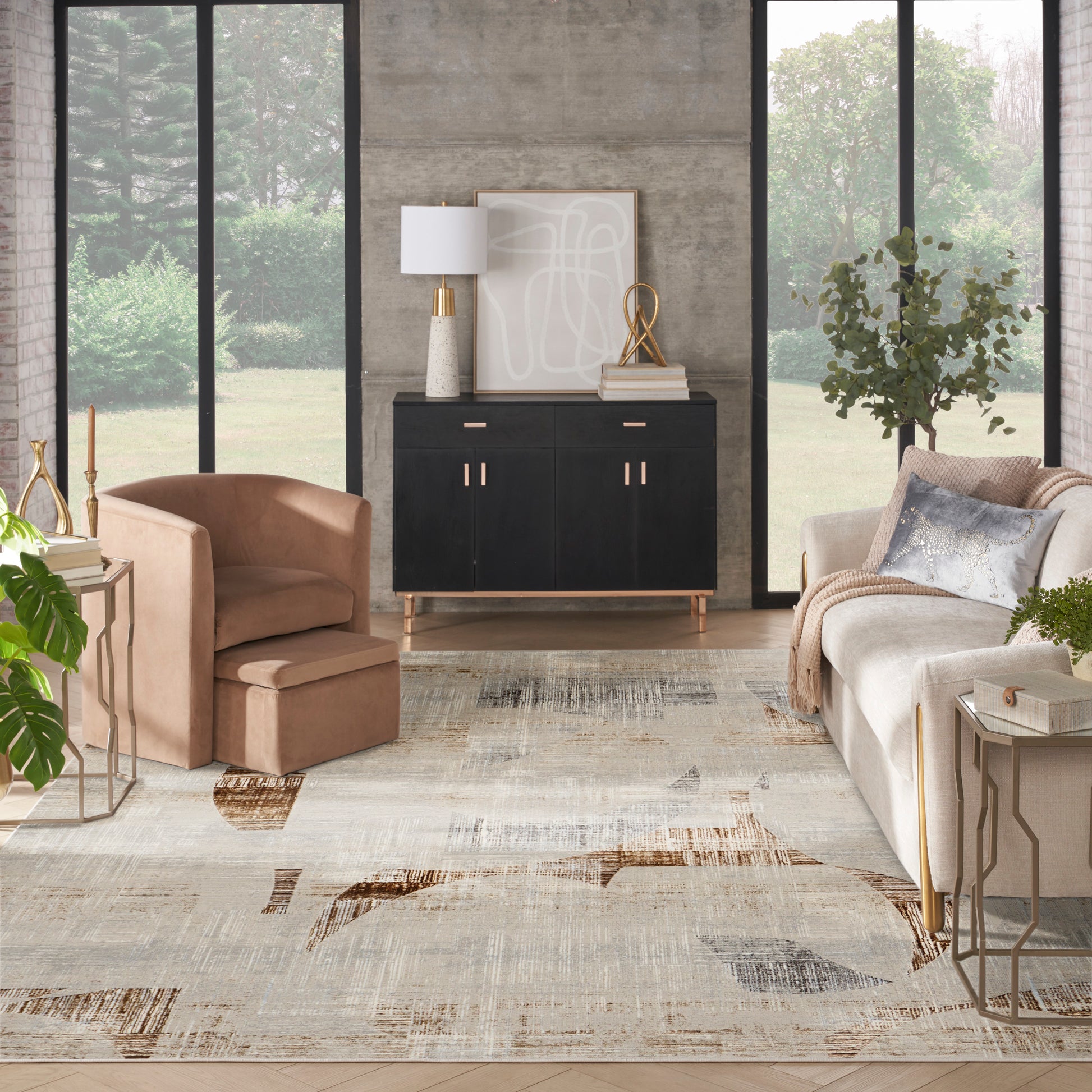 Modern living room with black sideboard featuring gold handles, tan leather chair, beige sofa, abstract neutral rug.