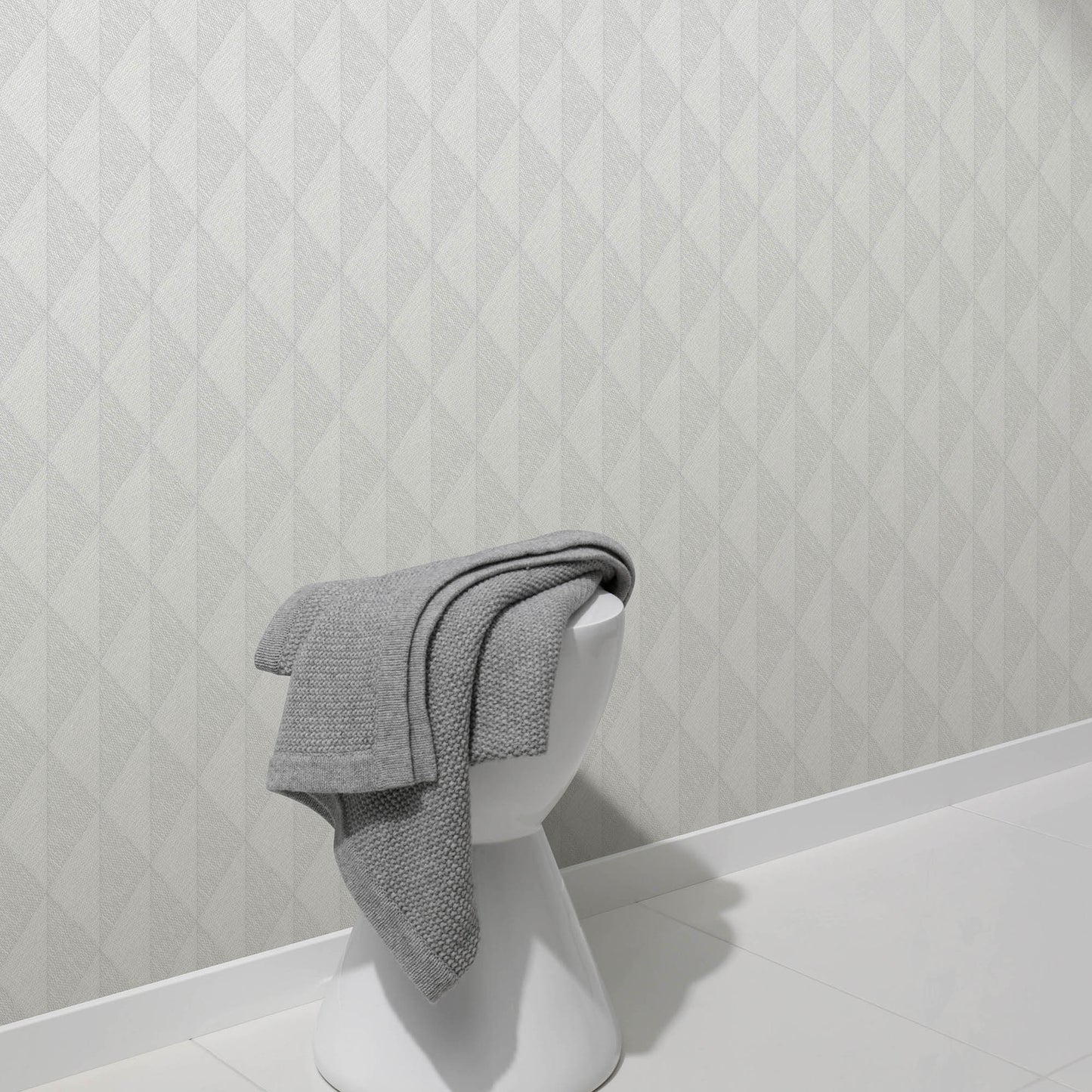 Gray woven-diamond wallpaper with a pale geometric pattern, shown on the wall behind a white bust display.