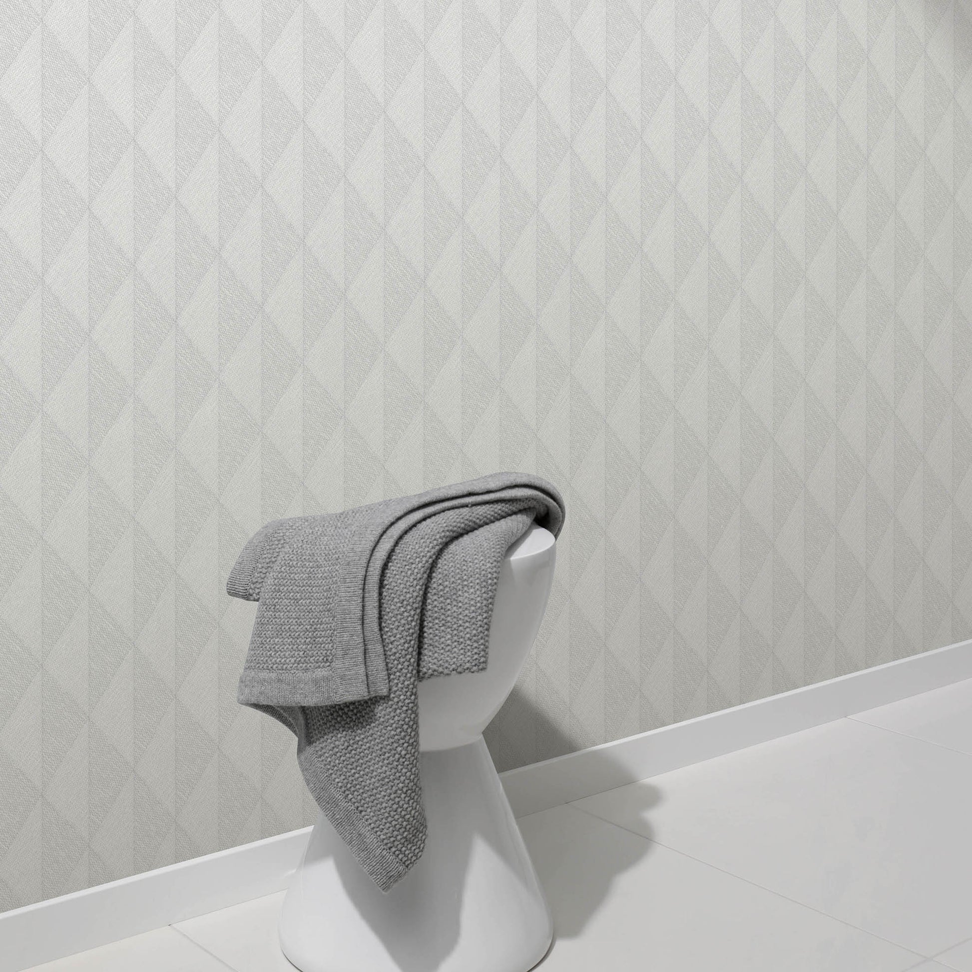 Gray woven-diamond wallpaper with a pale geometric pattern, shown on the wall behind a white bust display.