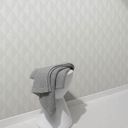 Gray woven-diamond wallpaper with a pale geometric pattern, shown on the wall behind a white bust display.