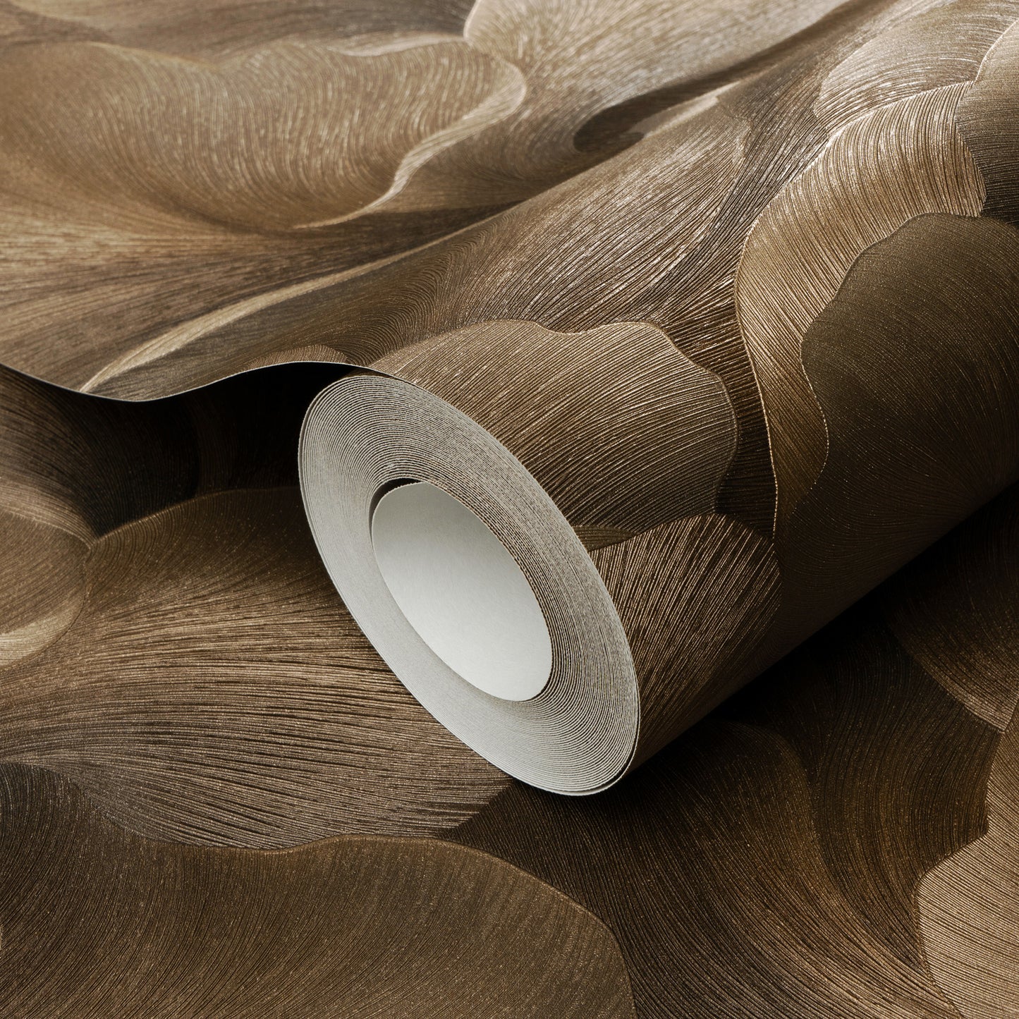 Brown textured wallpaper roll with flowing leaf-like pattern in warm tan tones.