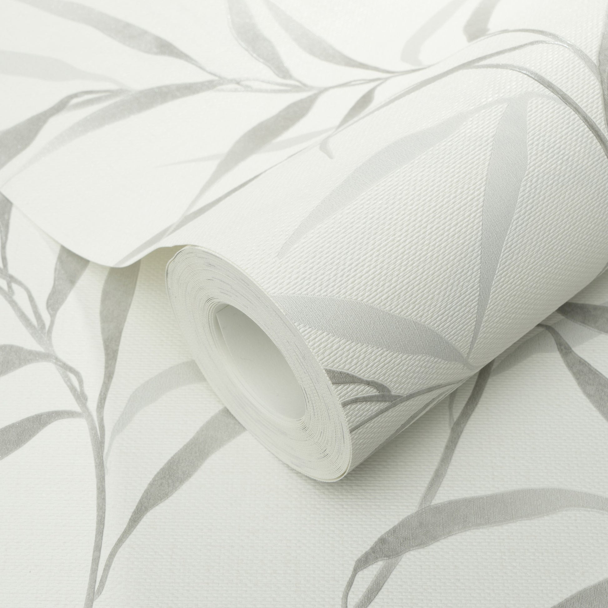 Roll of white wallpaper with light gray botanical leaf pattern; vinyl, textured, rolled up.