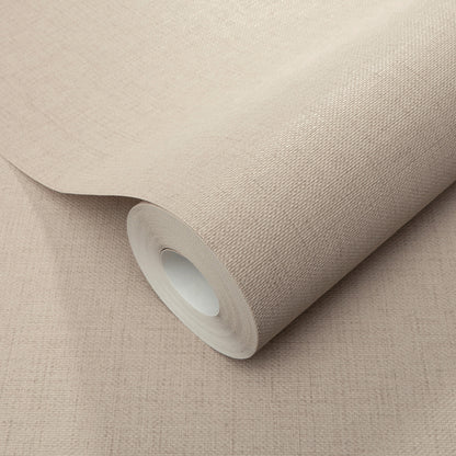 Beige wallpaper roll with woven texture and white inner core on a beige surface.