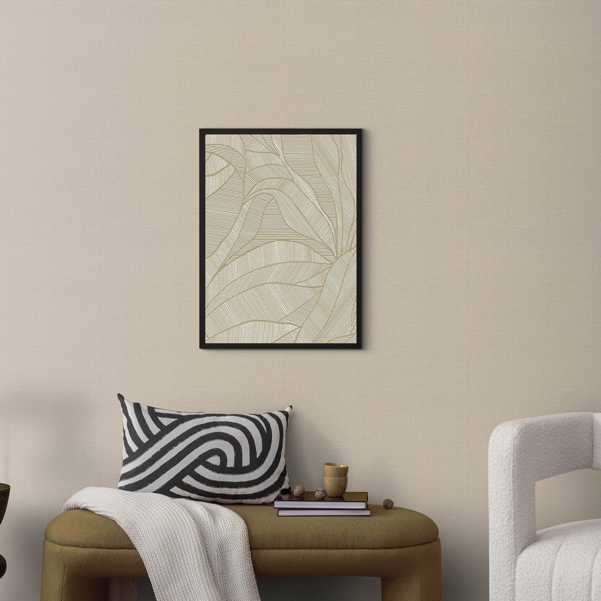 Taupe wallpaper with a jute texture on a neutral wall, with a tan ottoman, black-and-white swirl pillow, and a white throw.