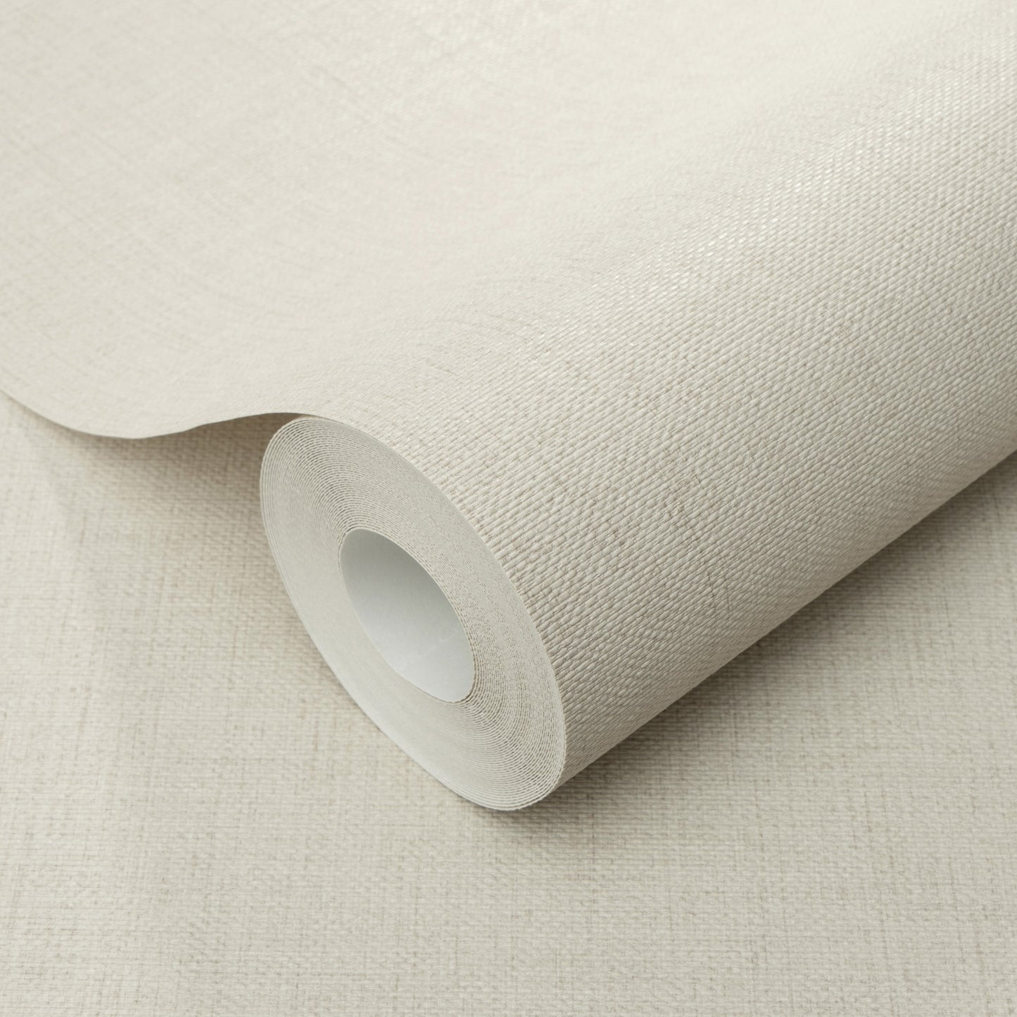 Beige wallpaper roll with a subtle jute-texture pattern on a cardboard core.
