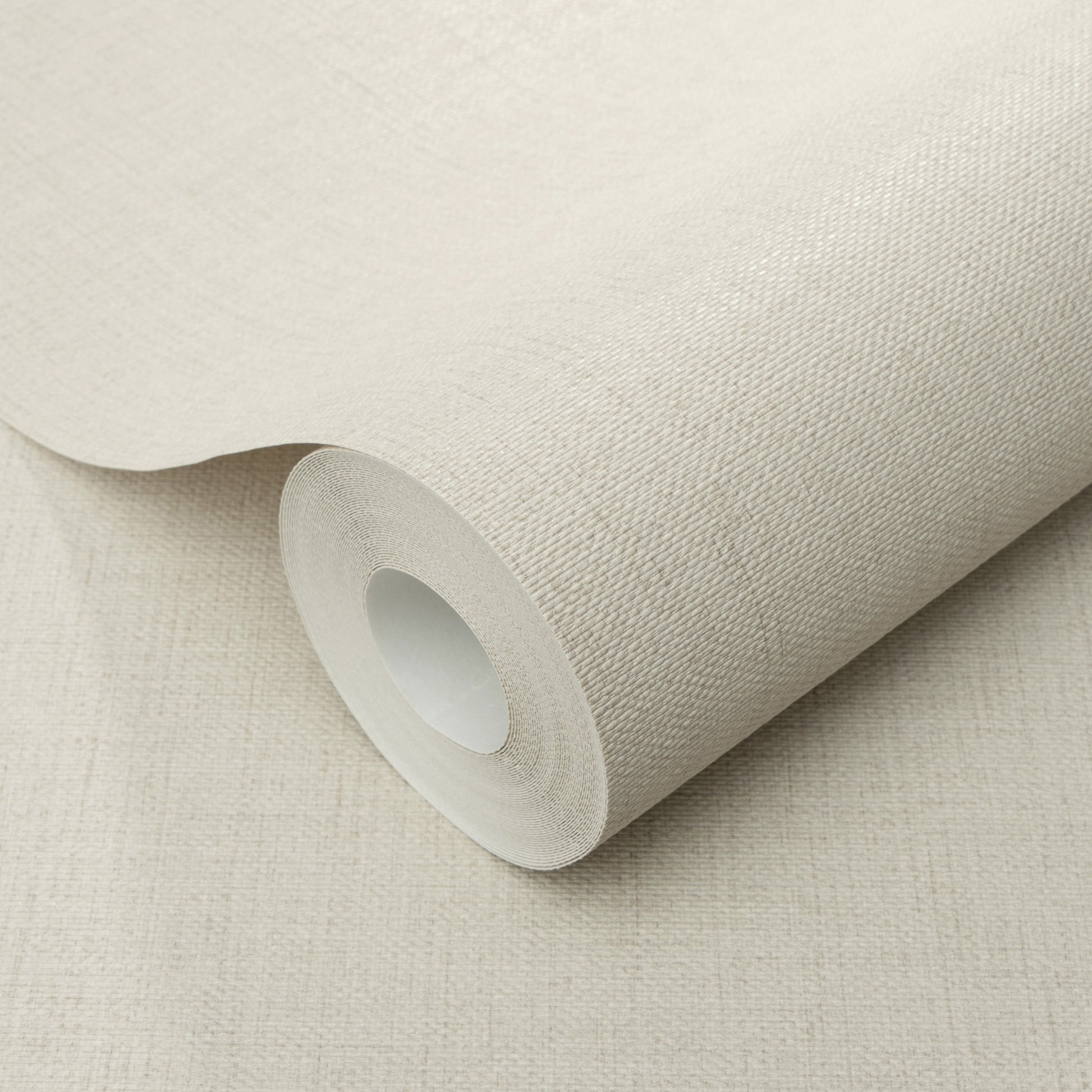 Beige wallpaper roll with a subtle jute-texture pattern on a cardboard core.